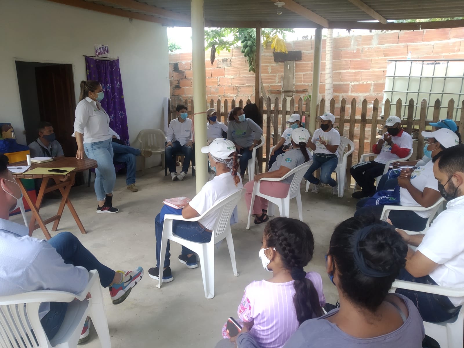 Taller en la comunidad con grupo de personas y funcionario dictando charla